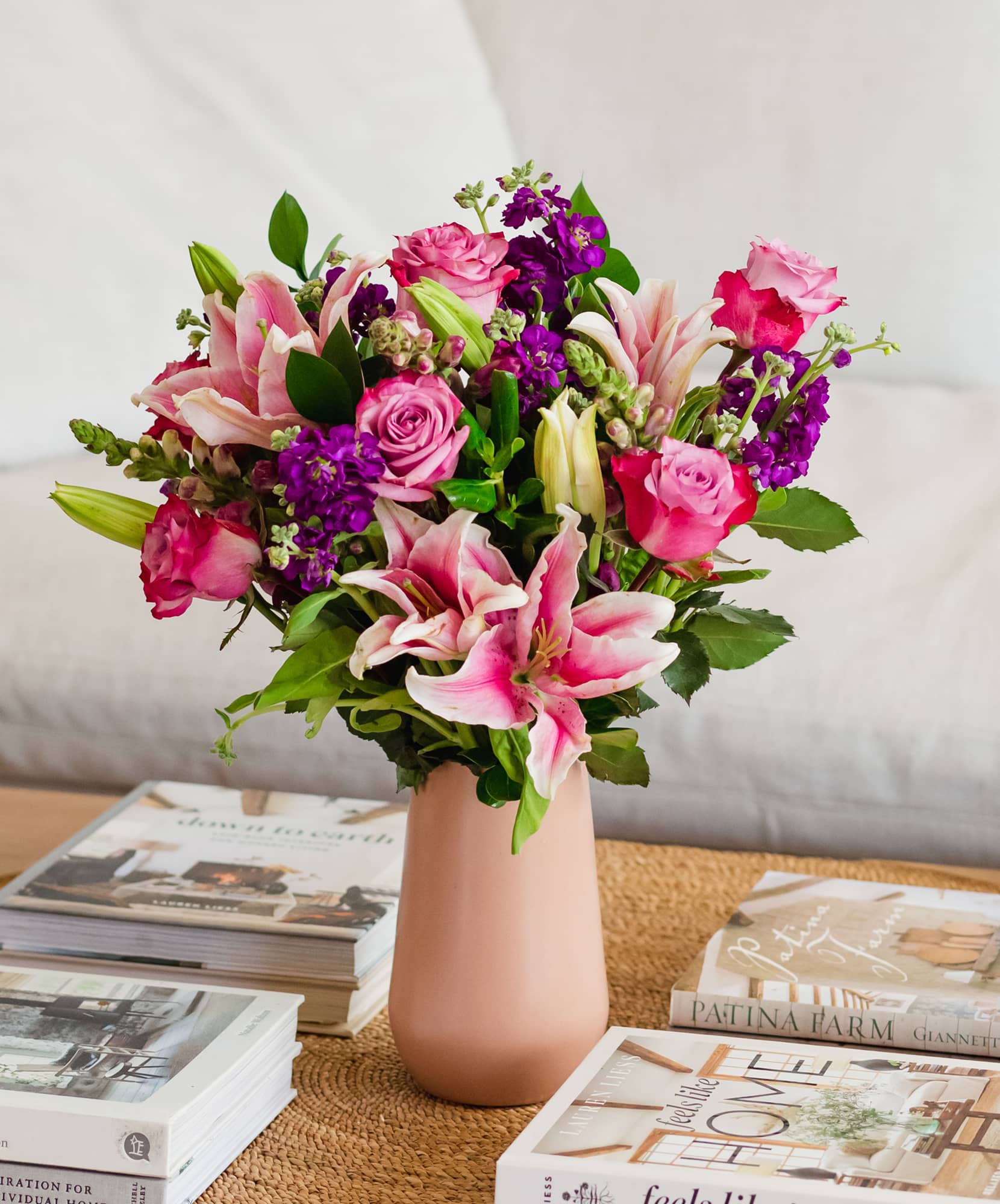 Vibrant floral arrangement featuring pink lilies, roses, and purple blooms in a chic vase.