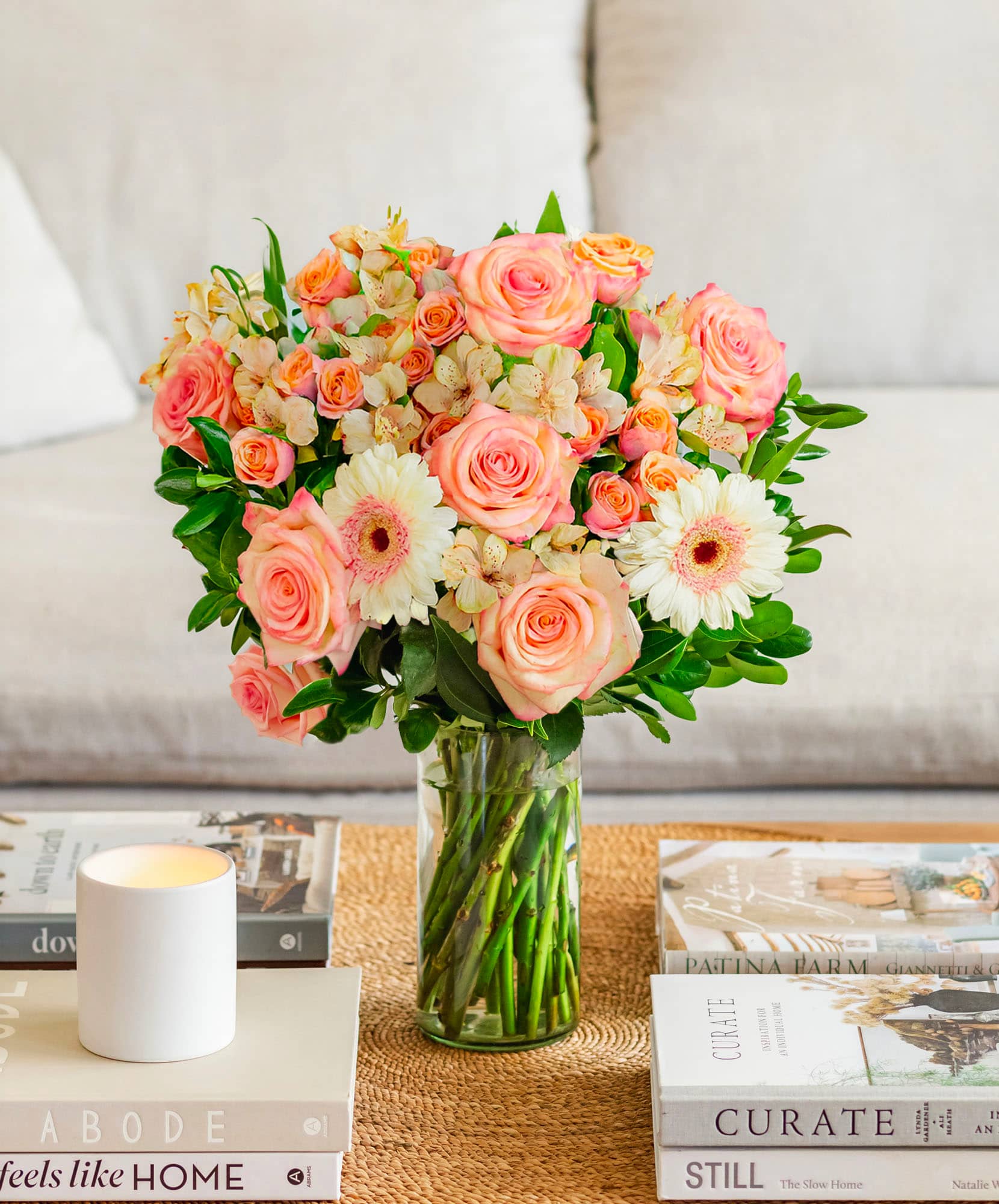 Vibrant floral arrangement featuring pink roses, daisies, and alstroemeria in a glass vase.