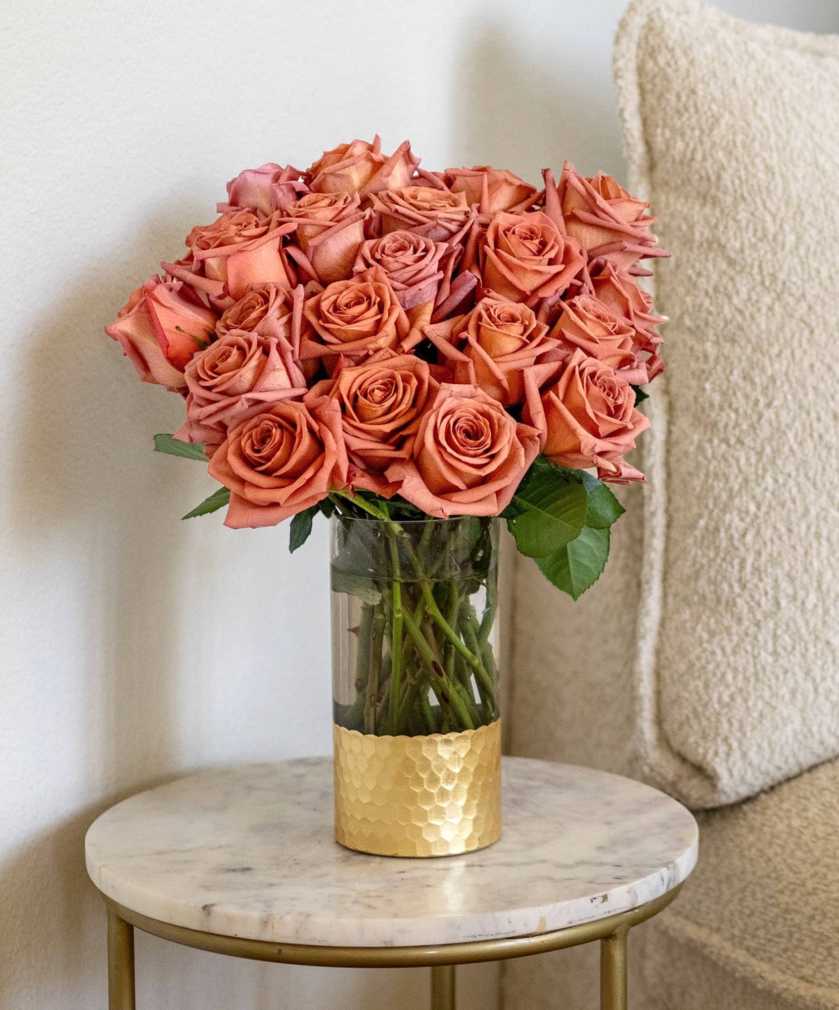 Elegant bouquet of peach roses in a glass vase, adding charm to any decor.